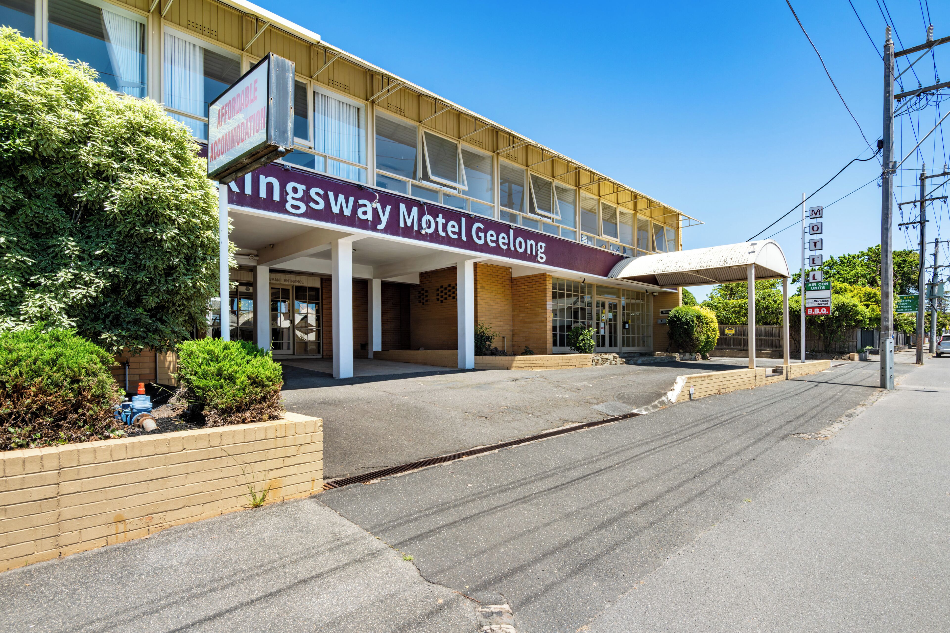 Kingsway Motel Geelong mit überdachtem Eingang und Schild, das bezahlbare Unterkünfte anbietet.