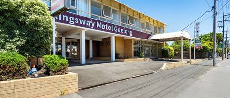 A Kingsway Motel Geelong with a covered entrance and a signboard advertising affordable accommodation.