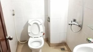 Une petite salle de bain avec des toilettes, un lavabo et une douche.