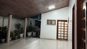 A spacious indoor area with a wooden ceiling, tiled floor, and potted plants. - Casa Ampla com 4 Suítes com Escritório, Aceita Animais de Estimação (São Pedro Teresina)
