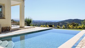 A rectangular swimming pool with clear blue water, surrounded by a stone deck and a low stone wall. - House with garden and private pool 6km beach (Calonge)