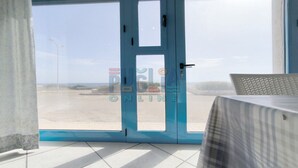 Une pièce dotée d’une grande porte vitrée donnant sur un espace de stationnement.