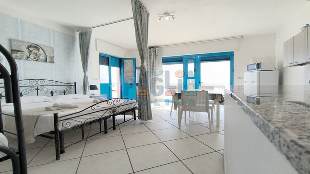Une chambre d’hôtel avec un lit, un bureau et une kitchenette.