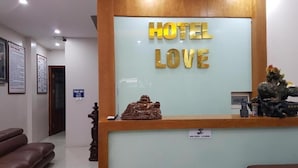 Ein Hotelrezeptionstresen mit einem Schild, auf dem 'HOTEL LOVE' steht.