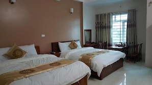 Ein Hotelzimmer mit zwei Betten, einem Schreibtisch und einem Stuhl.