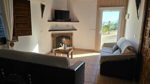 A room with a fireplace, a television, a sofa, and a bed. - Holiday Home 'Casa Rural Villa Campito' with Mountain View, Private Pool and Wi-Fi (Antequera)