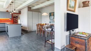Et moderne køkken med spiseplads, et fjernsyn og et rustikt skab.