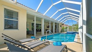 Un área de piscina techada al aire libre con sillas de descanso y un patio.