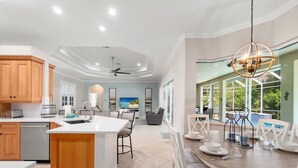 Una cocina amplia con armarios de madera, una isla grande y un comedor con vista al exterior.