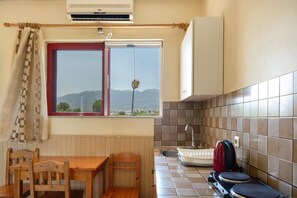 A kitchen with a window, a table, chairs, a sink, and a kettle. - Apartment 'Golden Sun Two-bedroom Apt 2' with Sea View, Shared Pool and Wi-Fi (Tigaki 0)