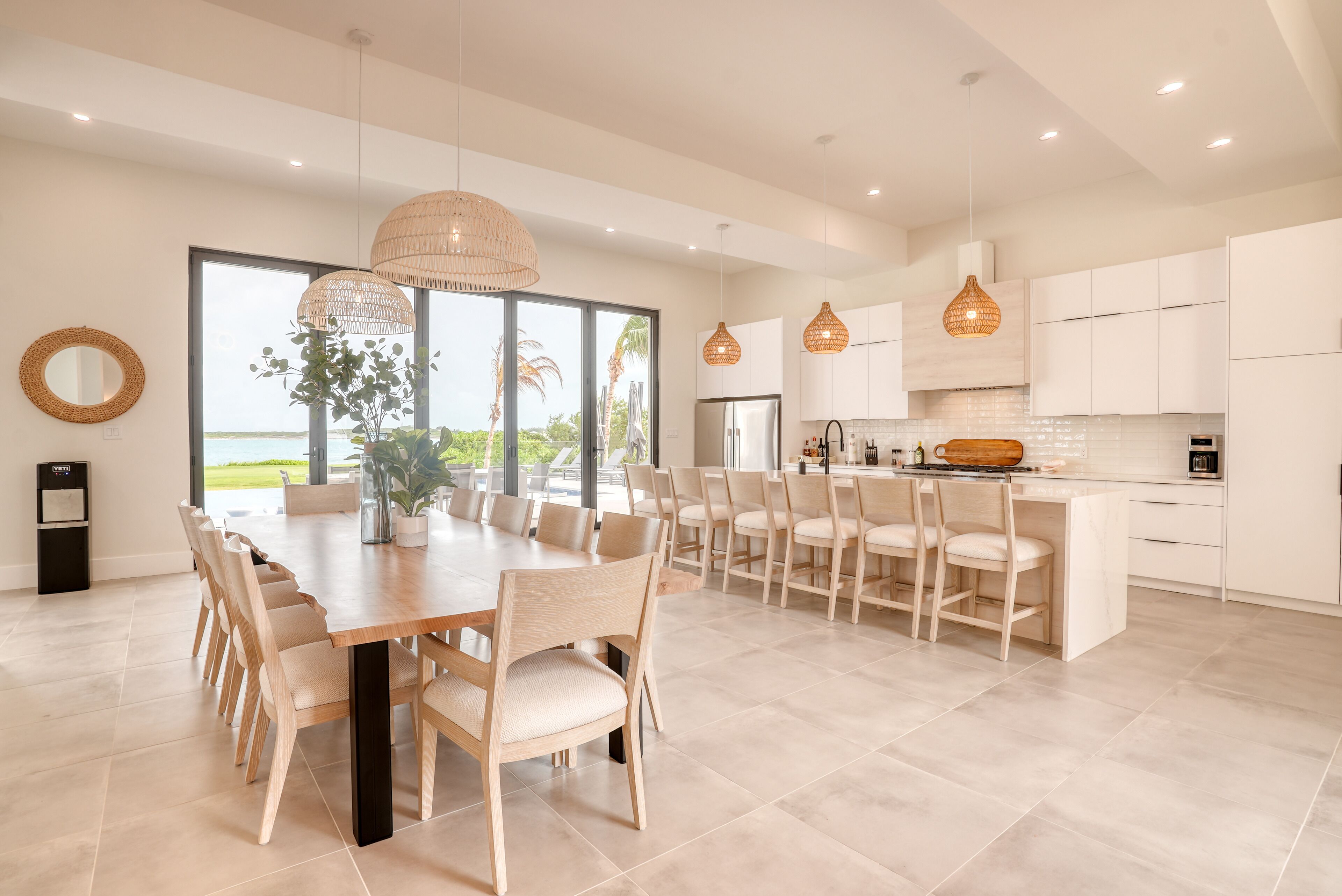 A modern kitchen with white cabinets, a large island, and pendant lighting.