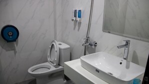 Un baño con inodoro, lavabo y ducha.