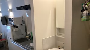 Et lille køkken med vask, mikroovn og minikøleskab.