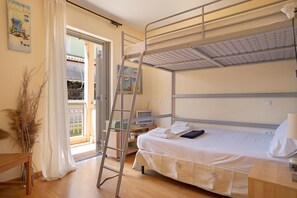 A bunk bed with a desk, a TV, and a window with a view.