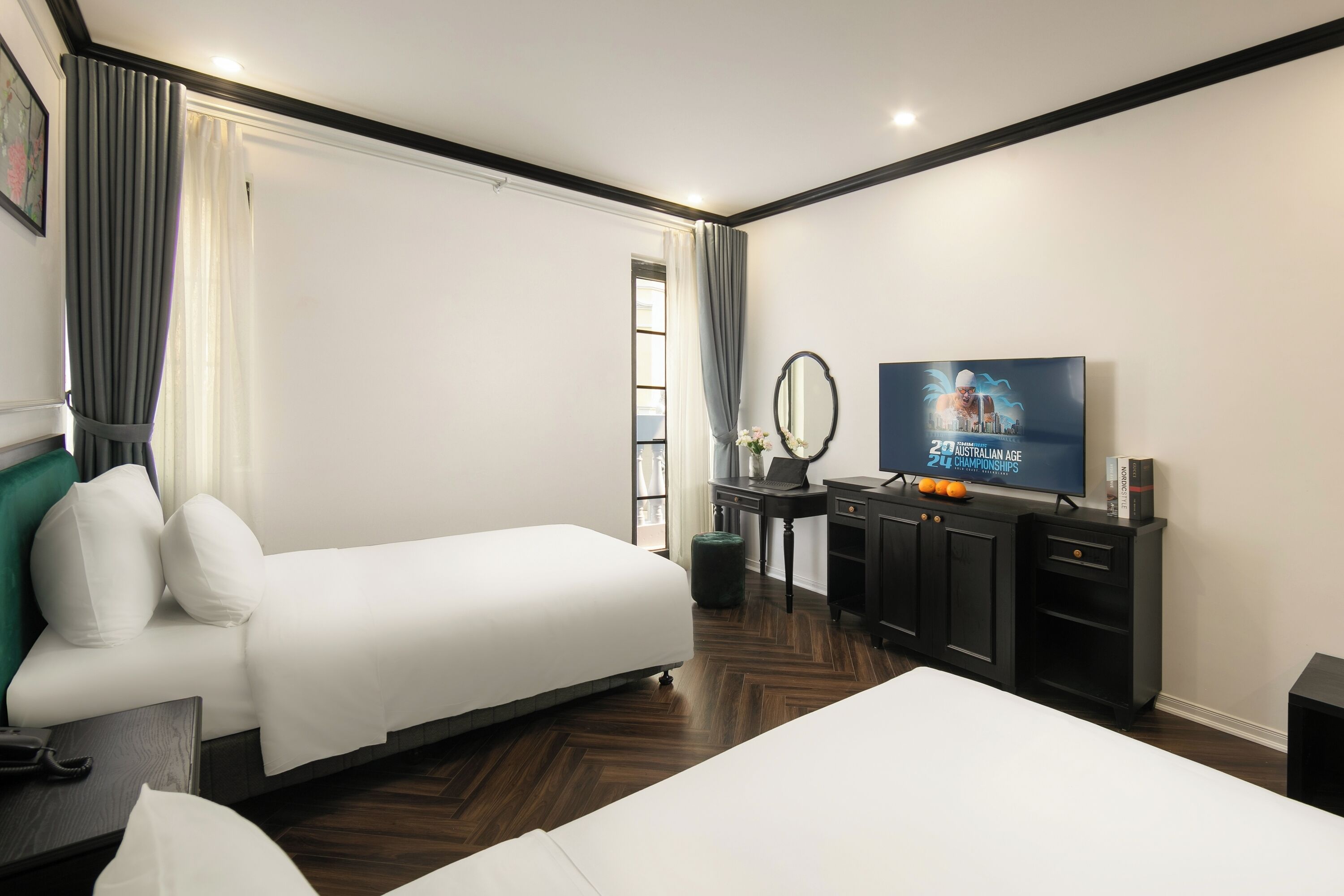 A hotel room with a bed, a desk, a television, and a wardrobe.