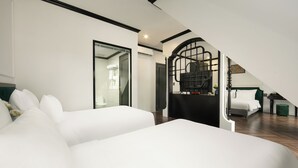 Een moderne slaapkamer met een groot bed, een trap naar een hoger gelegen niveau en uitzicht op een badkamer.