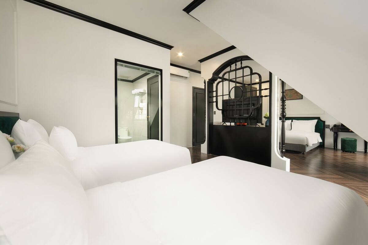 Un dormitorio moderno con una cama grande, una escalera que lleva a un nivel superior y vistas a un baño.