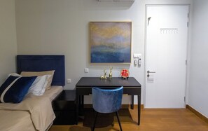 Une chambre à coucher avec un lit, un bureau, une chaise, un climatiseur, un tableau et une porte.