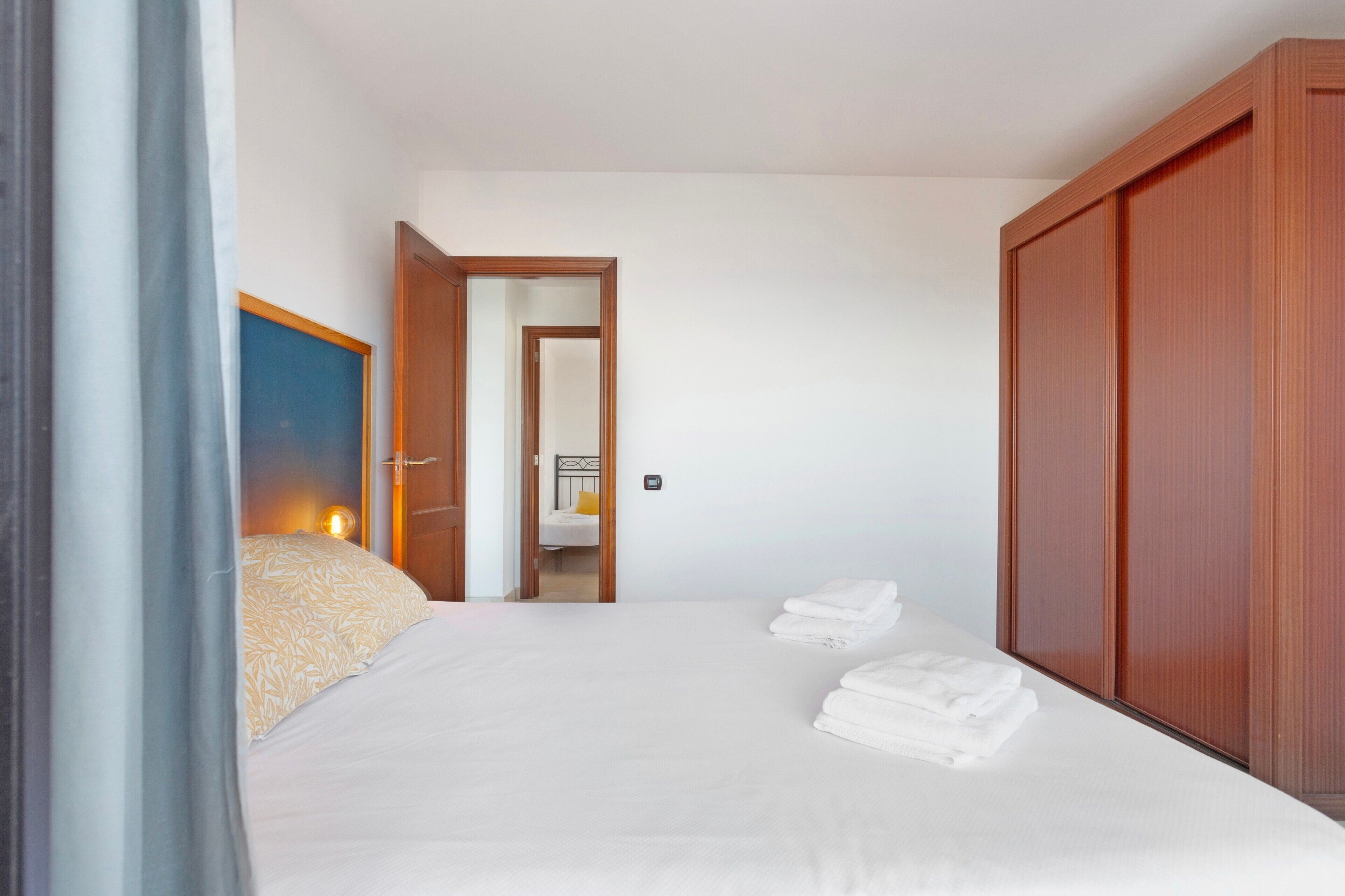 Une chambre d’hôtel comprenant un lit, une armoire et une porte donnant sur une autre pièce.