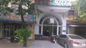 A building with a sign that reads "Hotel." There is a car parked in front, and a motorcycle is parked to the left. - Love Hotel Hoang Mai HN- by Bay Luxury (Hanoi)