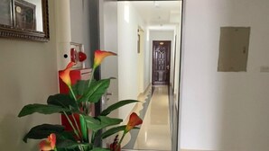 A hallway with a potted plant, a mirror, and a door leading to another room. - Love Hotel Hoang Mai HN- by Bay Luxury (Hanoi)