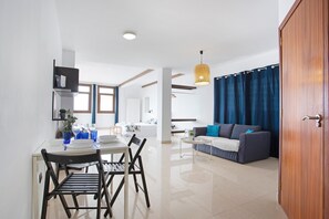 Un espace de vie moderne comprenant un coin repas, un canapé et une porte en bois.