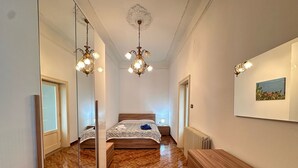 A bedroom with a wooden bed, a mirror, a radiator, and a picture on the wall.