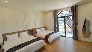A hotel room with two beds, a large window with a view of a bridge, and a mirror on the wall. - Storij Home & Coffee (Lam Vien - Da Lat)