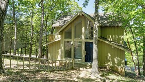 Una cabana de fusta amb una finestra gran, envoltada d'arbres.