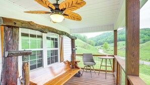 A wooden deck with a bench, a table, and a chair, overlooking a green landscape. - Hike & Relax: Blue Ridge Mountain Retreat! (Burnsville)