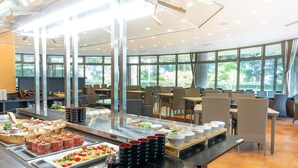 Ein Buffetbereich mit verschiedenen Speisen und eine Sitzecke mit Tischen und Stühlen.