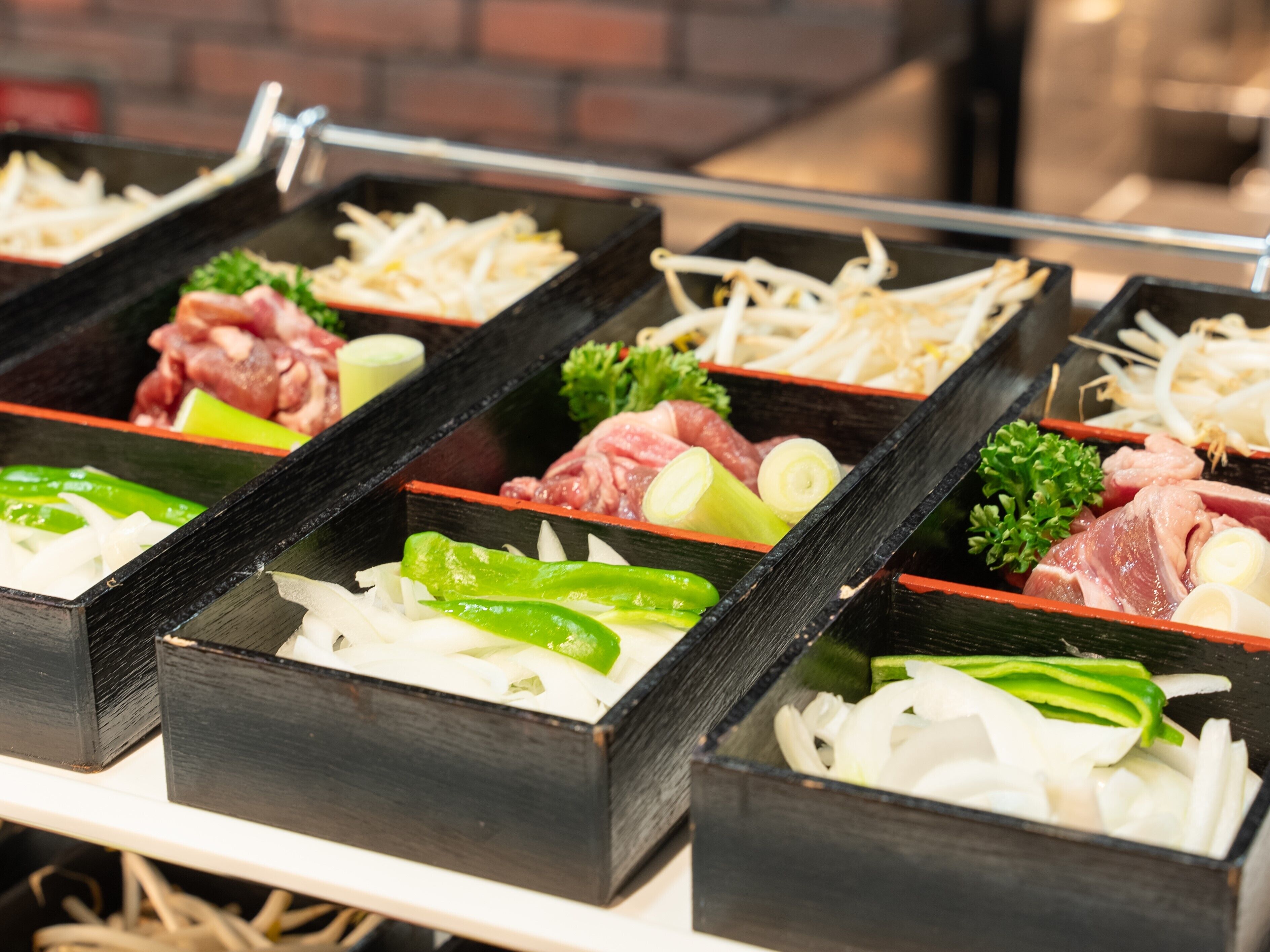 A buffet with various food items including meats, vegetables, and cheese.