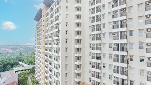 A high-rise residential building with multiple balconies and air conditioning units. - Capital O 93931 Elzio Property (Depok)