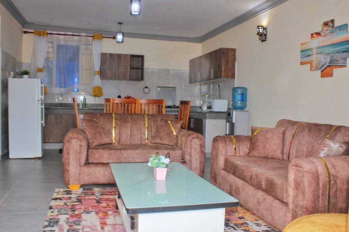 A living room with two sofas, a coffee table, and a kitchen in the background.