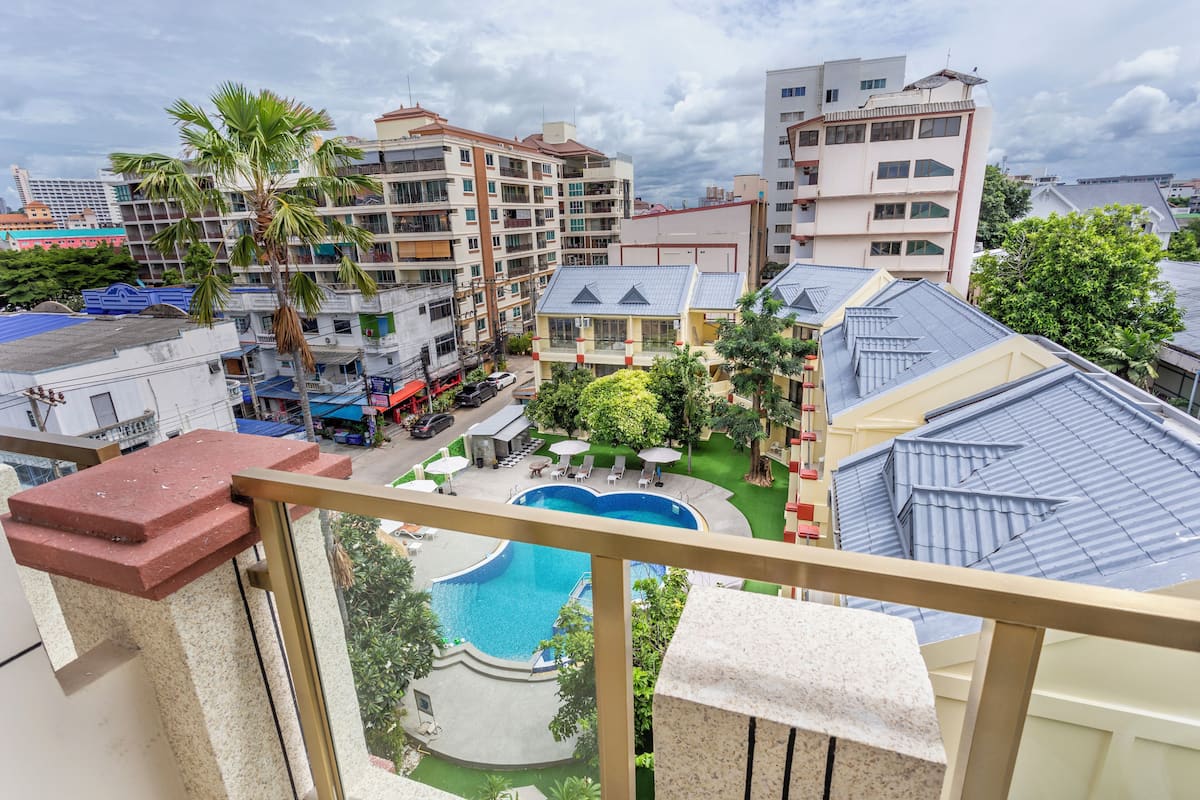 Un quartier résidentiel doté d’une piscine entourée de verdure et offrant une vue sur des immeubles à plusieurs étages.