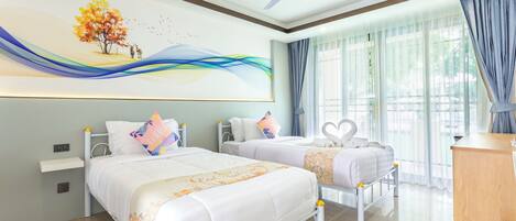 Une chambre d’hôtel avec deux lits, un ventilateur de plafond, une grande fenêtre avec des rideaux et un tableau au mur.