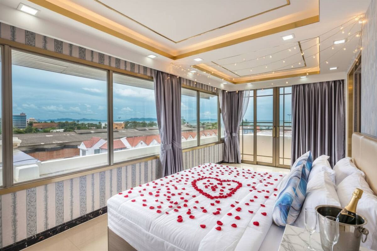 Une chambre d’hôtel avec un grand lit, une vue sur la ville et un balcon.