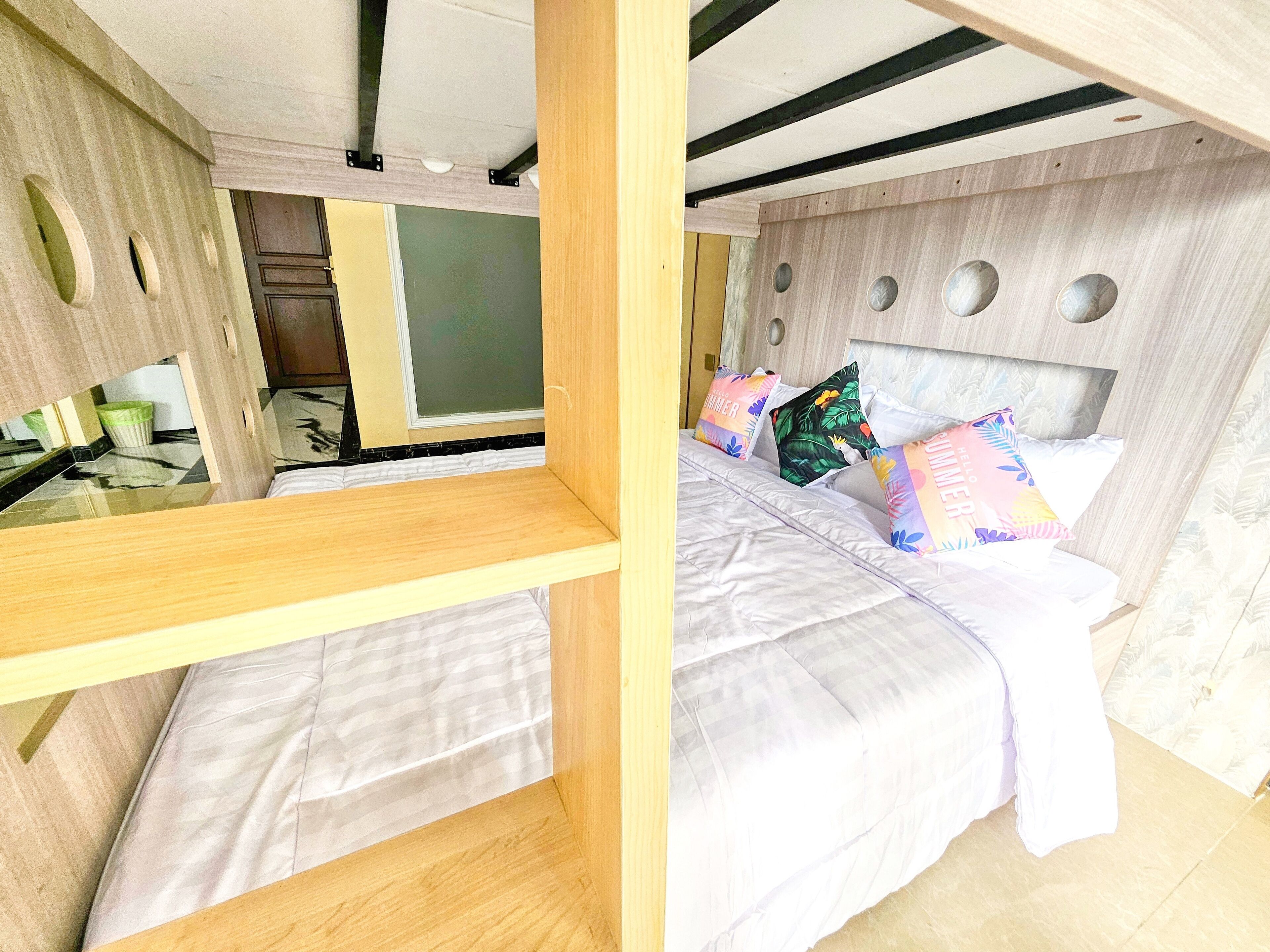 A bedroom with a bed, pillows, and a wooden headboard.