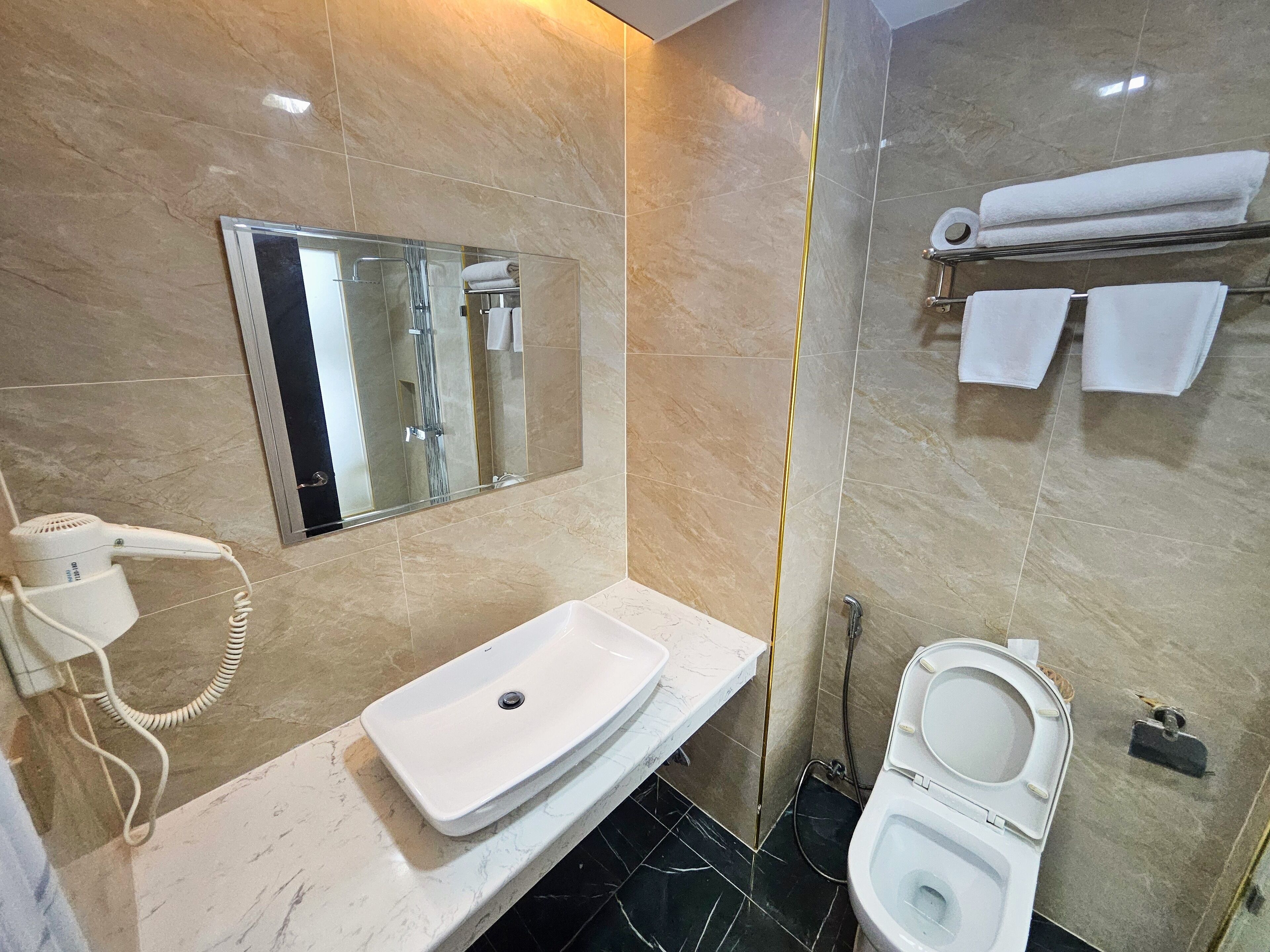 Une salle de bain équipée d’un lavabo, de toilettes et d’une douche à parois de verre.