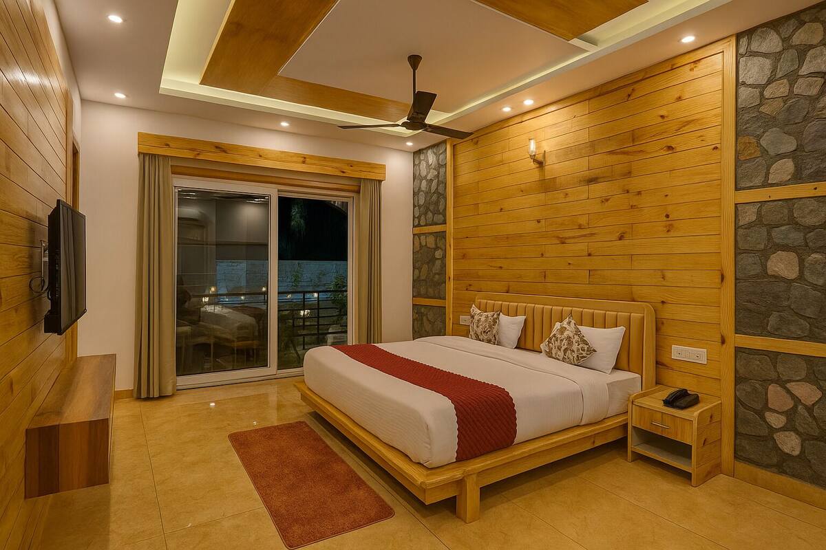 Un dormitorio moderno con cabecera de madera, una cama grande, una mesita de noche, un televisor y una pared de acento de piedra.