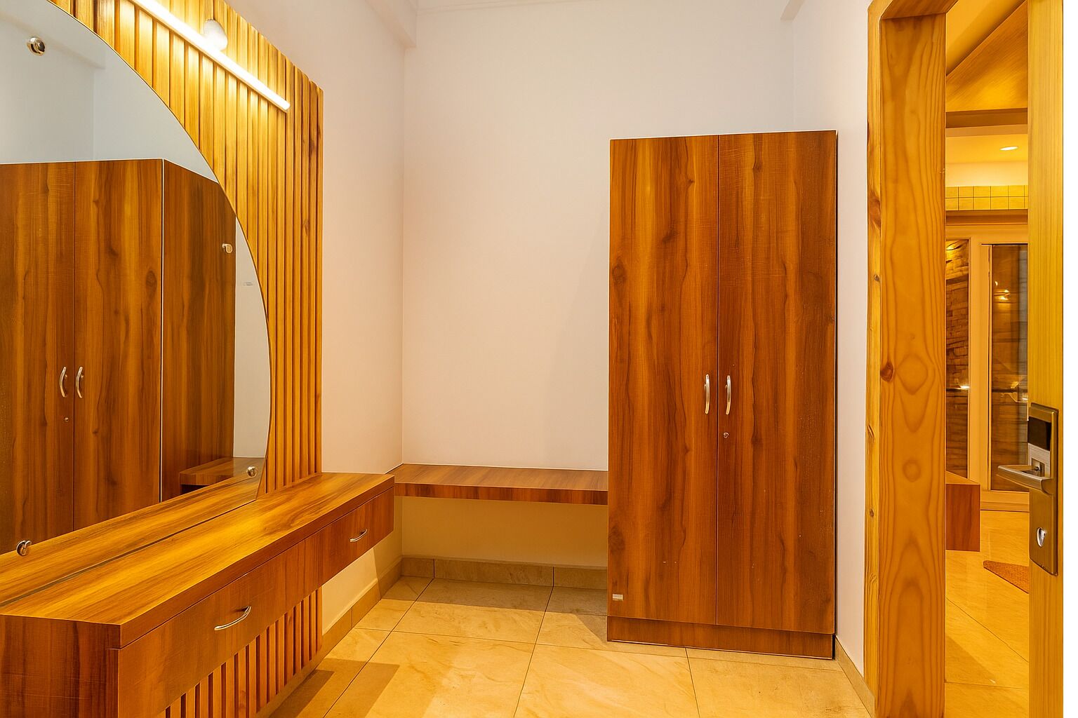 A modern bathroom with wooden cabinetry, a vanity with a mirror, and a shower area.