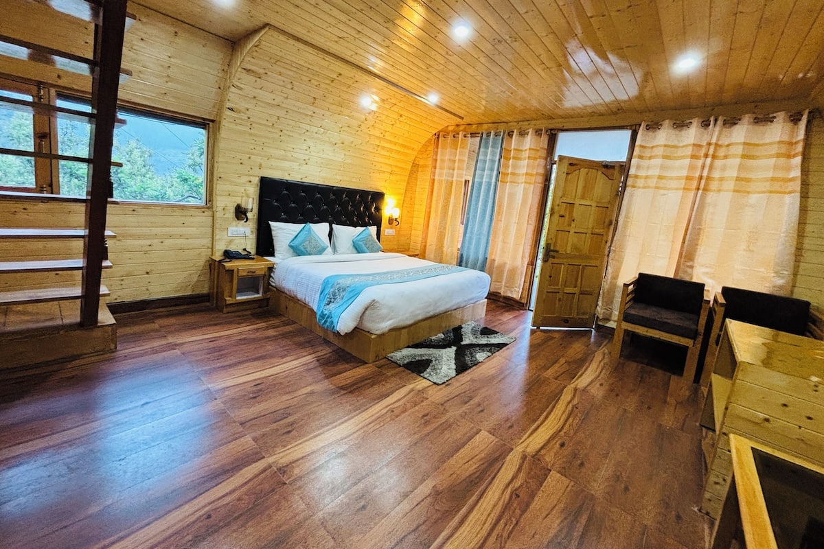 Camera da letto in legno con un letto, un comodino e una sedia di legno.