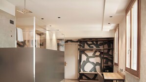 A modern hotel room with a glass partition, a wooden desk, and a patterned wall. - Parc Hotel San Pietro  (Caprino Veronese)