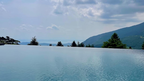 A clear view of a swimming pool with a mountainous landscape in the background. - Parc Hotel San Pietro  (Caprino Veronese)