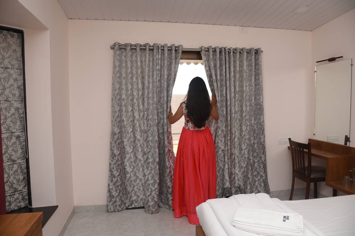 A hotel room with a bed, a desk, and a chair.