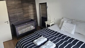 Ein Hotelzimmer mit einem großen Bett, einem Nachttisch, einem Spiegel und einem Kleiderschrank.
