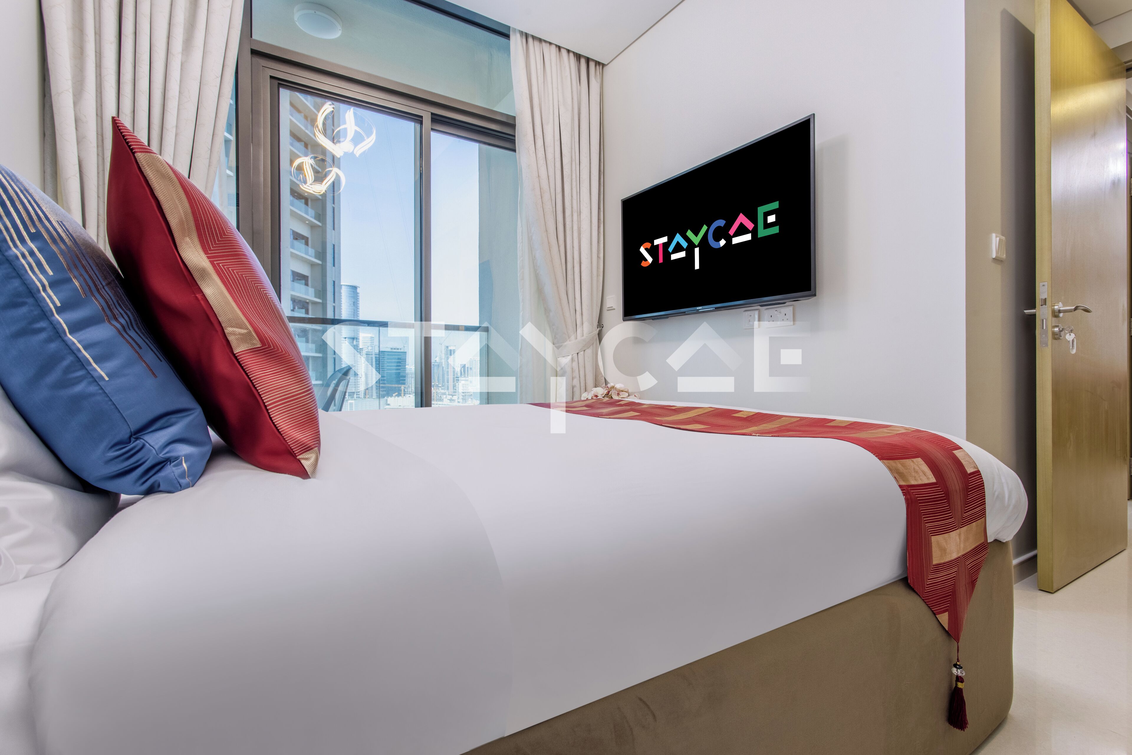 Une chambre d’hôtel avec un lit, une télévision et une vue sur la ville.