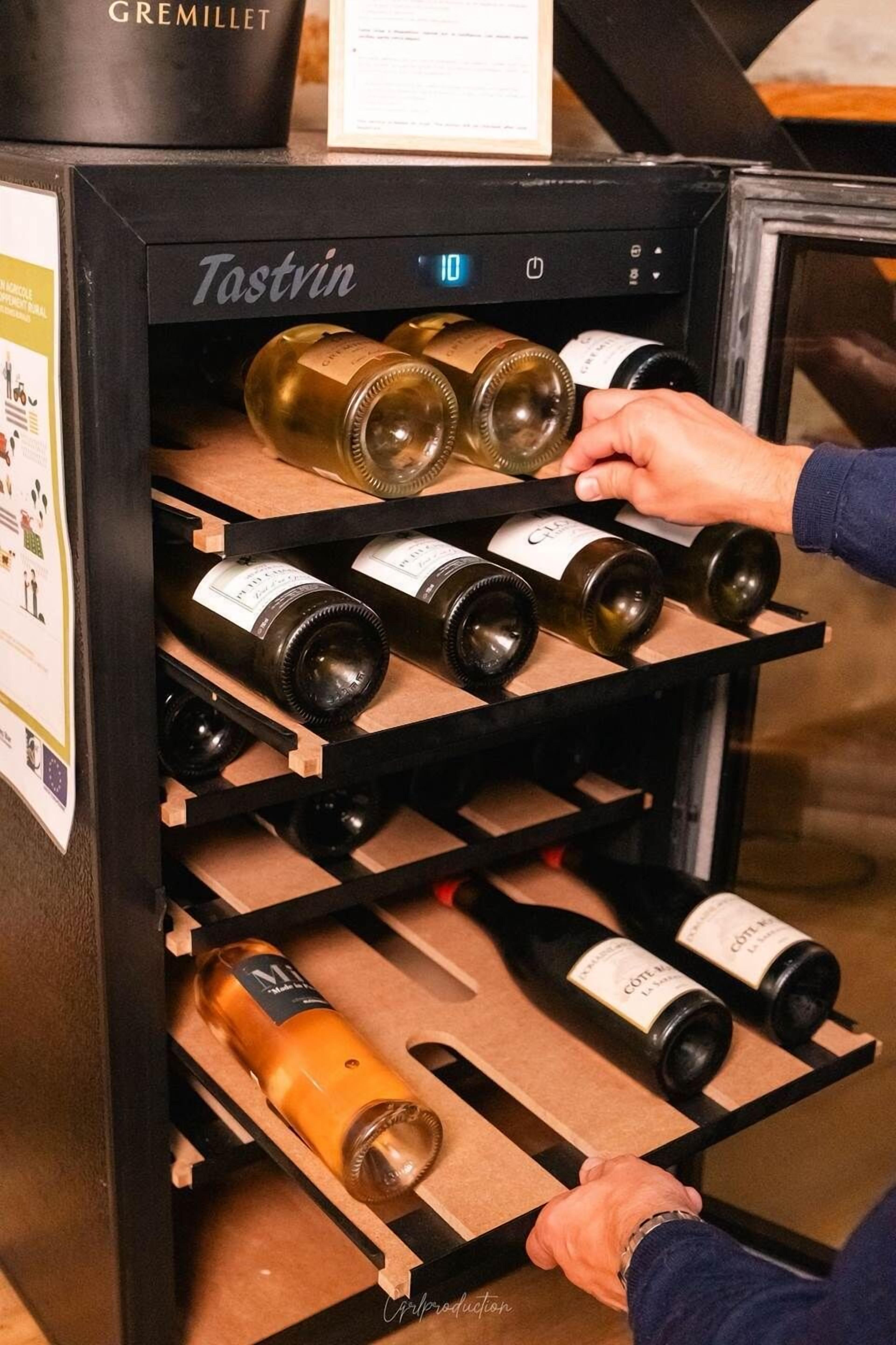 A wine cooler with multiple shelves holding bottles of wine.