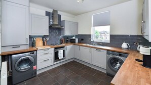 A modern kitchen with built-in appliances, grey cabinets, and a large window. - Fairview Apt B - 2BR Gem in West Bridgford Centre (West Bridgford Nottingham)
