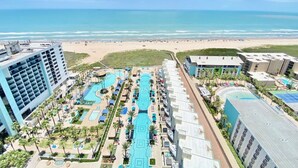 Een resort met meerdere zwembaden, een strand en uitzicht op de oceaan.